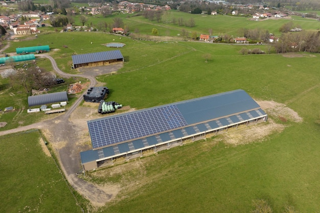 Luchtfoto van boerderijgebouw met fotovoltaïsche zonnepanelen gemonteerd op het dak voor het produceren van schone ecologische elektriciteit Productie van hernieuwbare energieconcept