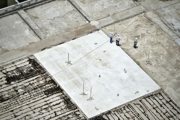 Luchtfoto van bouwvakkers die op de bouwplaats staan