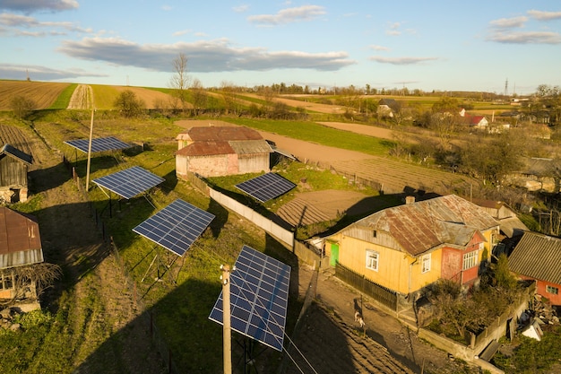 Luchtfoto van boven naar beneden van zonnepanelen in groene landelijke dorpswerf.