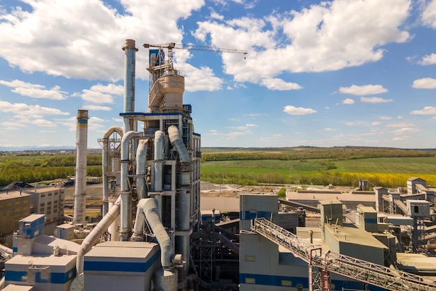 Luchtfoto van cementfabriek met hoge betonnen fabrieksstructuur en torenkraan op industrieel productiegebied Vervaardiging en wereldwijd industrieconcept