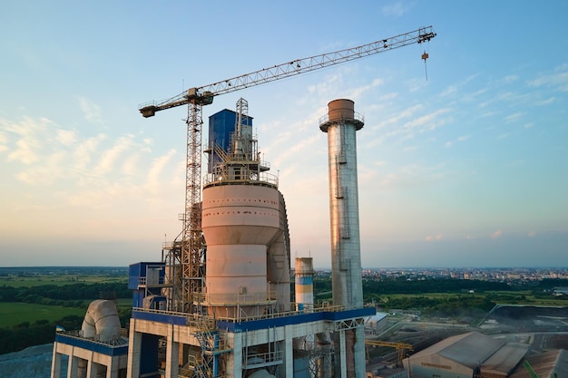 Luchtfoto van cementfabriek met hoge betonnen fabrieksstructuur en torenkraan op industriële productielocatie Vervaardiging en wereldwijd industrieconcept