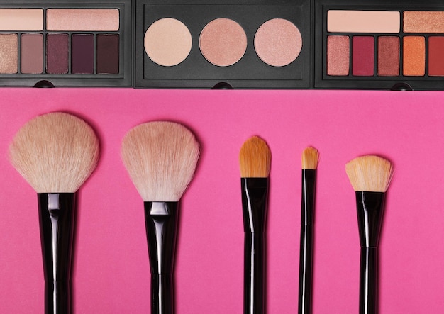 Luchtfoto van cosmetische schoonheidsproducten die uitlopen op een roze achtergrond