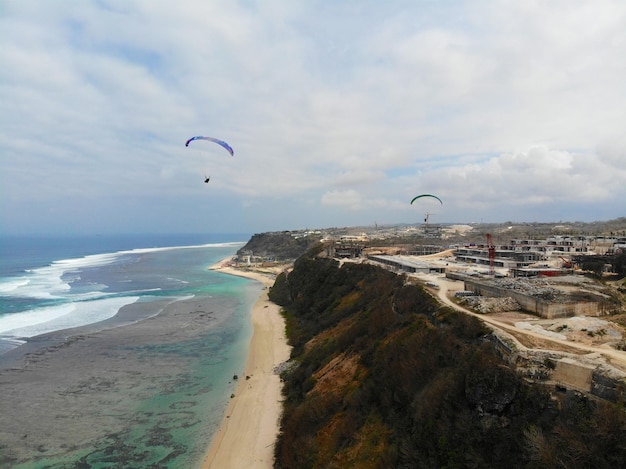 Luchtfoto van de blauwe zee met rotsklif aan de zandige kustlijn Bali