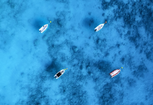 Luchtfoto van de boten in helder blauw water op zonnige dag in de zomer. Bovenaanzicht van drone van jacht, zandstrand in de Middellandse Zee. Reizen in Oludeniz, Turkije. Tropisch landschap met motorboot