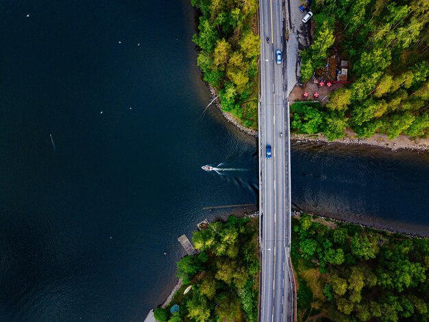 Luchtfoto van de brug met een boot die eronder vaart Blauw meer met zomerhuizen op het platteland van Finland