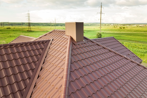 Luchtfoto van de dakconstructie van het huis bedekt met bruine metalen tegelplaten.