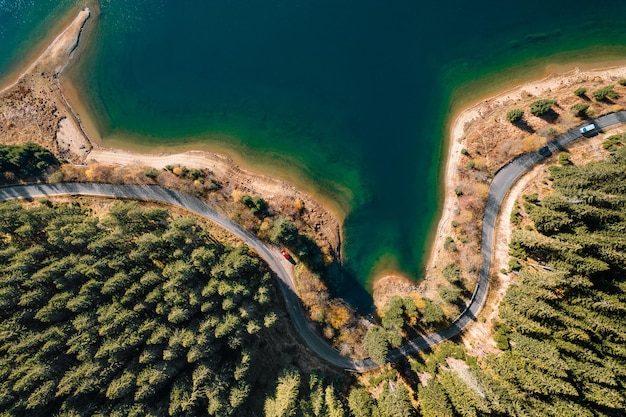 Foto luchtfoto van de kronkelende weg bij het meer en het bos