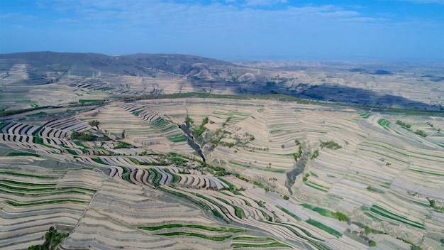 Luchtfoto van de massaproductie van terrasvormige boerderijvelden tijdens het droge zomerseizoen in de provincie Tianshui Gansu