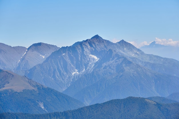 Luchtfoto van de scherpe bergtoppen met gletsjers in de blauwe atmosferische waas