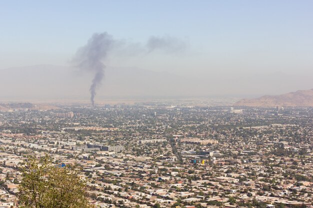 Luchtfoto van de stad Santiago met vuurrook op de achtergrond Zonnige dag op de vervuilde hoofdstad van Chili