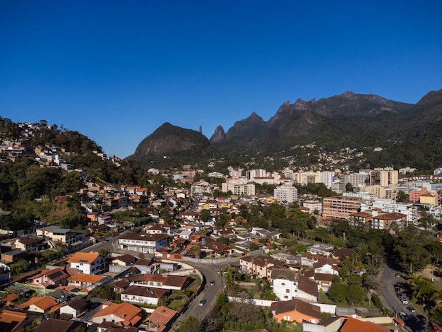 Luchtfoto van de stad teresopolis bergen en heuvels met blauwe lucht en veel huizen in het berggebied van rio de janeiro brazilië drone foto araras teresopolis zonnige dag zonsopgang