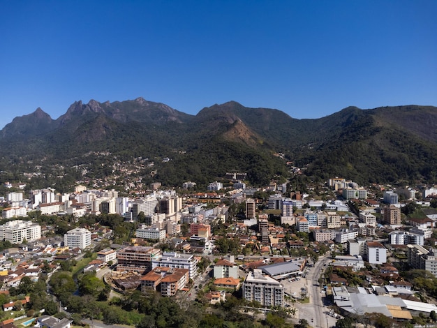 Luchtfoto van de stad teresopolis bergen en heuvels met blauwe lucht en veel huizen in het berggebied van rio de janeiro brazilië drone foto araras teresopolis zonnige dag zonsopgang