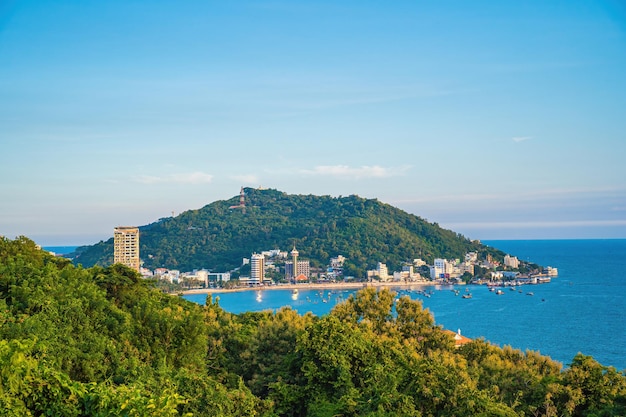 Luchtfoto van de stad Vung Tau met prachtige zonsondergang en zoveel boten en kabelbaan Panoramisch uitzicht op de kust van Vung Tau van bovenaf met golven kustlijn straten kokospalmen en Tao Phung berg in Vietnam