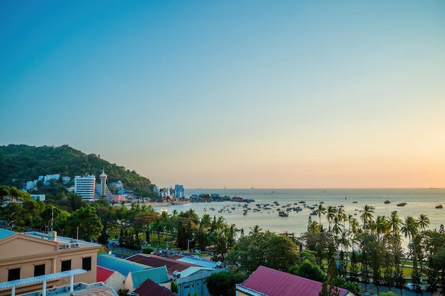 Luchtfoto van de stad Vung Tau met prachtige zonsondergang en zoveel boten Panoramisch uitzicht op de kust van Vung Tau van bovenaf met golven kustlijn straten kokospalmen en Tao Phung berg in Vietnam