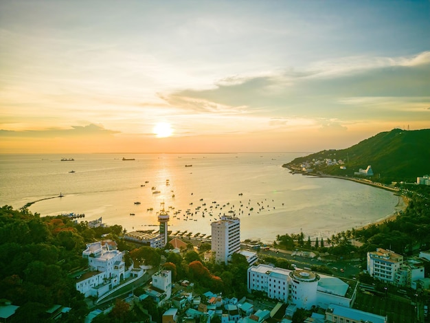 Luchtfoto van de stad Vung Tau met prachtige zonsondergang en zoveel boten Panoramisch uitzicht op de kust van Vung Tau van bovenaf met golven kustlijn straten kokospalmen en Tao Phung berg in Vietnam