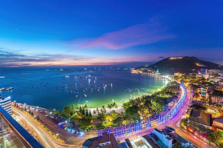 Luchtfoto van de stad Vung Tau met prachtige zonsondergang en zoveel boten Panoramisch uitzicht op de kust van Vung Tau van bovenaf met golven kustlijn straten kokospalmen en Tao Phung berg in Vietnam