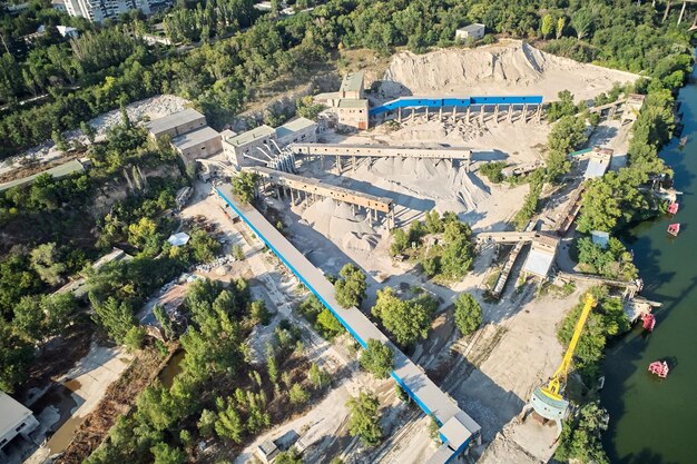 Luchtfoto van de verwerkingsfabriek met de zandfractionator aan de rand van een kwartszandgroevevijver voor wit kwartszand gemaakt met drone