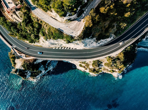 Luchtfoto van de weg langs de bergen en de oceaan of de zee Dronefotografie van bovenaf