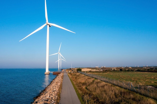 Luchtfoto van de windturbines. Groene ecologische energie opwekking. Windpark eco veld. Offshore en onshore windmolenpark groene energie op zee.