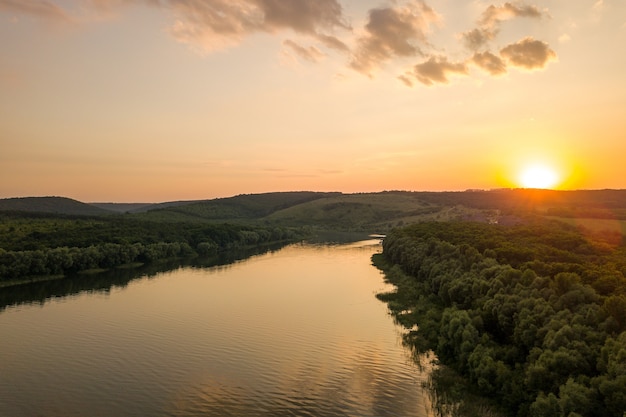 Luchtfoto van de zonsondergang over de brede rivier de Dnister en de rotsachtige heuvels in de verte in Bakota, onderdeel van het nationale park "Podilski Tovtry" in Oekraïne