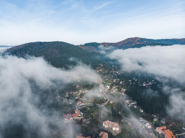 Luchtfoto van dorp in bergen wolken eroverheen. reisconcept