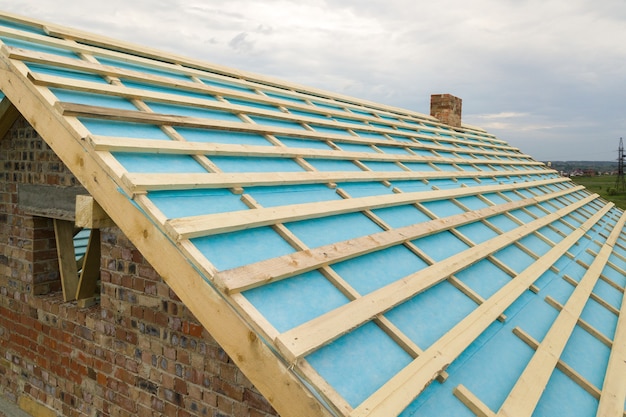 Luchtfoto van een bakstenen huis met houten dakframe in aanbouw.