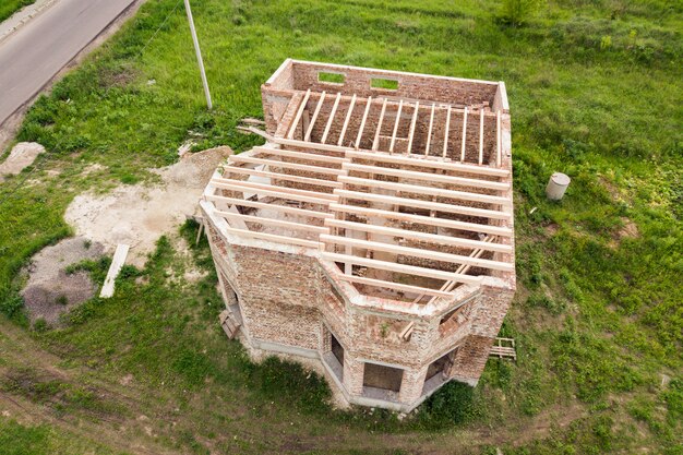 Luchtfoto van een bakstenen huis met houten plafond frame in aanbouw