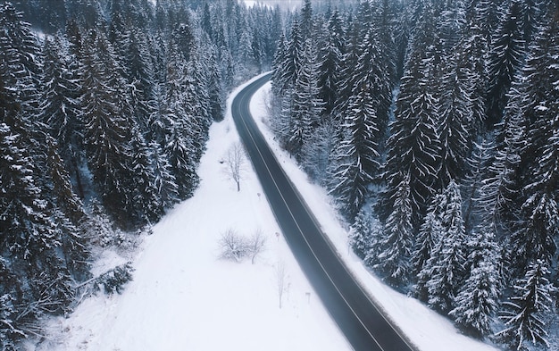 Luchtfoto van een bergweg in het bos van de winter