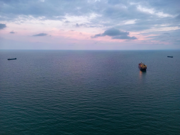 Luchtfoto van een bulkcarrier 's avonds toont een verbluffende weergave van lichten die weerkaatsen op het water terwijl het enorme schip door de golven snijdt