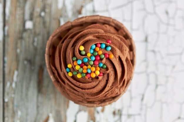 Luchtfoto van een chocolade cupcake met gekleurde snoepjes.