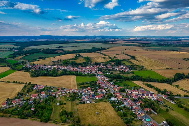 Luchtfoto van een Duits dorp omgeven door weiden, landbouwgrond en bos in Duitsland