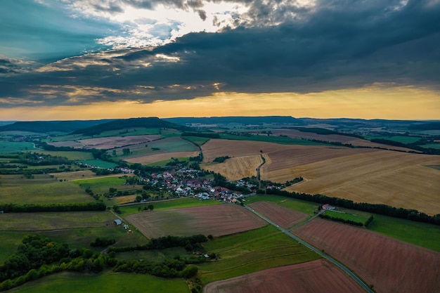 Luchtfoto van een Duits dorp omgeven door weiden, landbouwgrond en bos in Duitsland