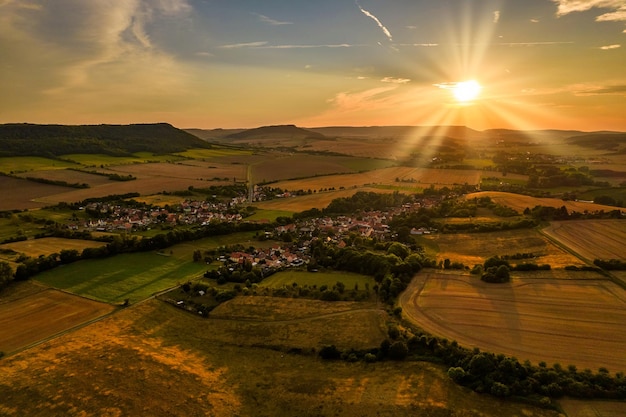 Luchtfoto van een Duits dorp omgeven door weiden, landbouwgrond en bos in Duitsland