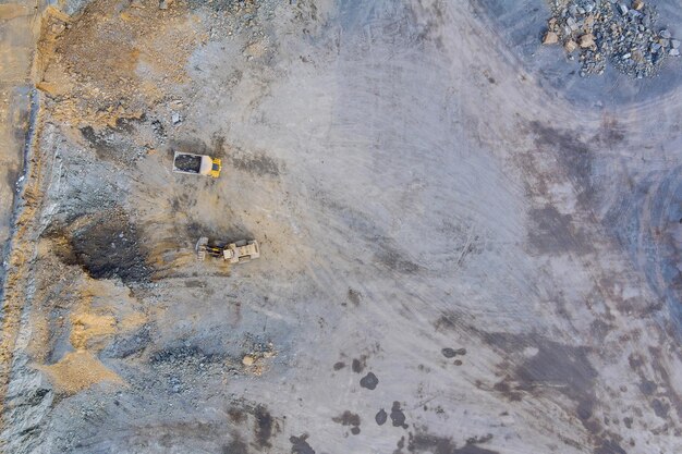 Luchtfoto van een graafmachine die granieten stenen in een steengroeve laadt