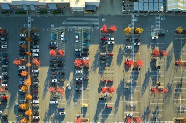 Luchtfoto van een groot parkeerterrein voor een rgocery-winkel met veel geparkeerde kleurrijke auto's parkeerterrein bij supercenter-winkelcentrum met lijnen en markeringen voor voertuigplaatsen en richtingen