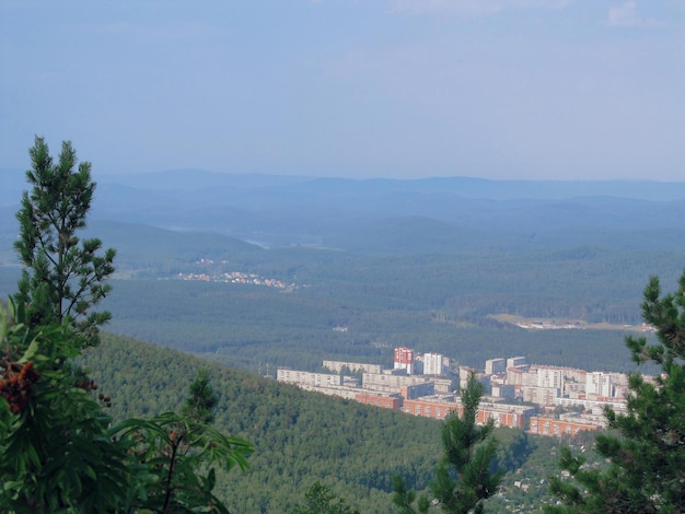 Luchtfoto van een kleine stad in een laagland in het midden van beboste bergen