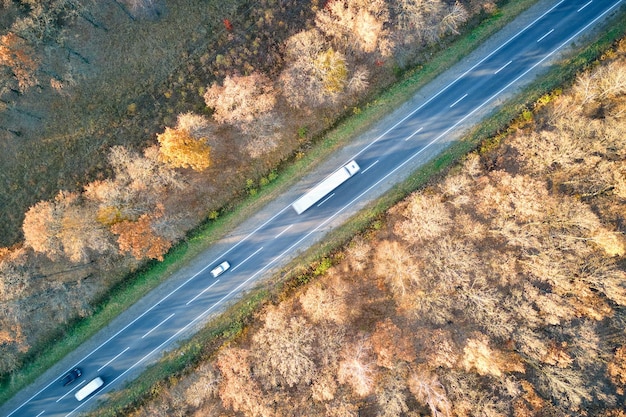 Luchtfoto van een semi-vrachtwagen met een vrachtaanhanger die 's avonds op de snelweg rijdt en goederen vervoert. Leveringstransport en logistiek concept