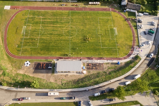 Foto luchtfoto van een voetbalveld op een stadion bedekt met groen gras in landelijk stadsgebied.