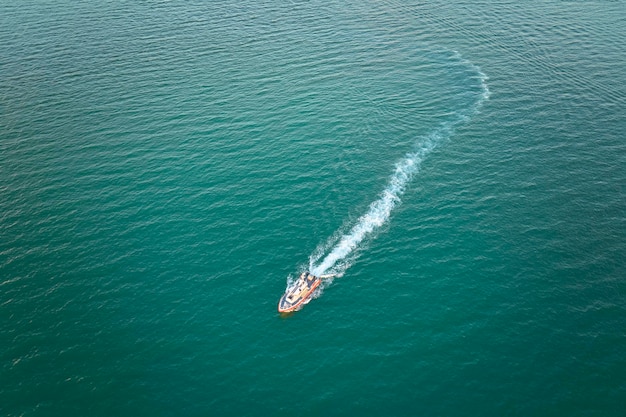 Luchtfoto van een wit jacht dat op golven van de zee zwemt met een rimpelend oppervlak Motorboot in beweging op de oceaan