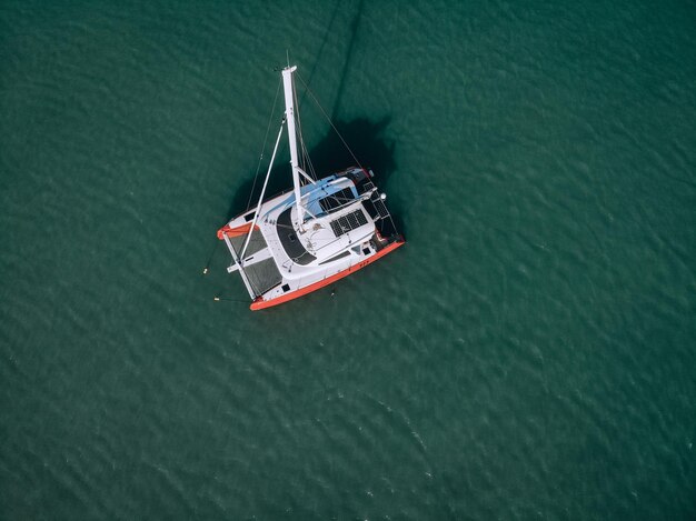 Foto luchtfoto van een zeiljacht in het turquoise water van de andamanse zee. phuket. thailand