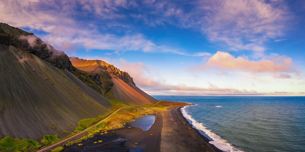 Luchtfoto van een zwart zandstrand en de Eystrahorn Mountains in IJsland