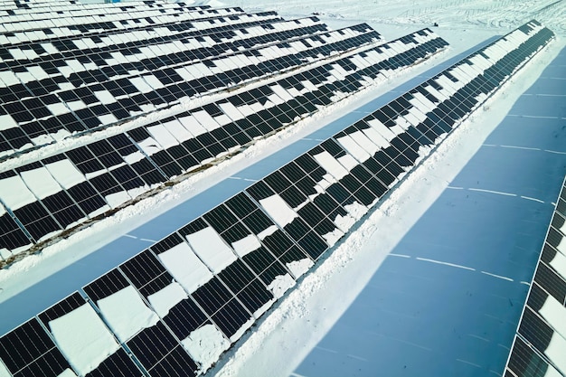 Luchtfoto van elektriciteitscentrale met zonnepanelen bedekt met sneeuw die in de winter smelt voor het produceren van schone energie Concept van lage effectiviteit van hernieuwbare elektriciteit in de noordelijke regio