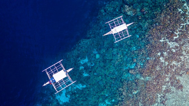 Luchtfoto van Filipijnse boten die bovenop heldere blauwe wateren drijven