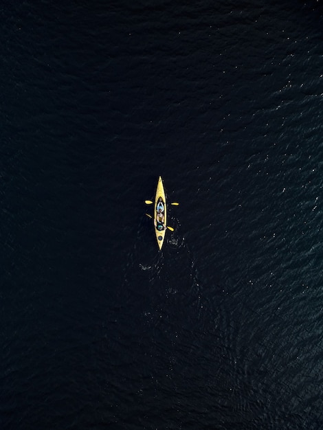 Luchtfoto van gele kajak in donkerblauw meerwater