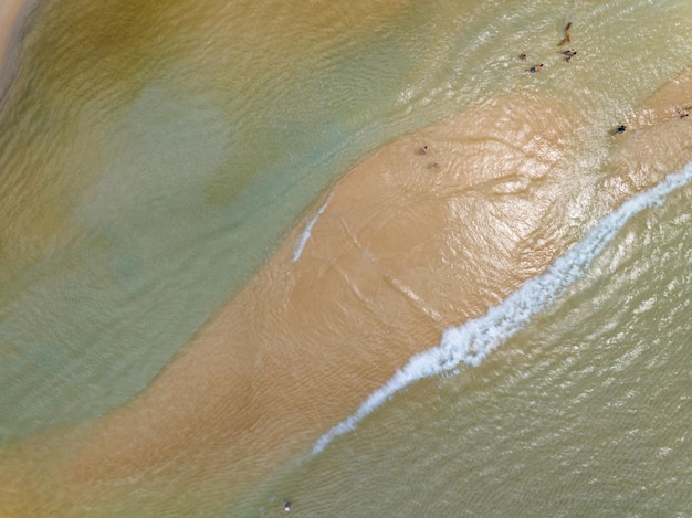 Luchtfoto van golven die op de zandkust botsenZeeoppervlakte oceaangolven achtergrondTopfoto strand achtergrond