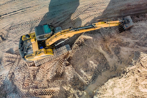 Luchtfoto van graafmachine die werkt in steengroeve of bouwplaats Industrieel bovenaanzicht achtergrondconcept Een mijngraafmachine graaft een kuil Verhuur van bouwmachines Aannemer