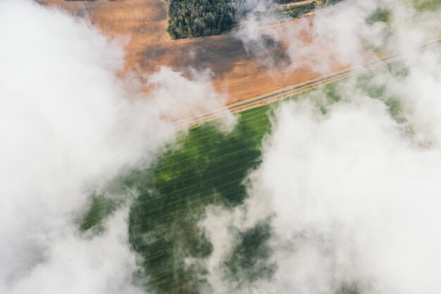 Foto luchtfoto van groene landbouwgrondvelden door witte wolken