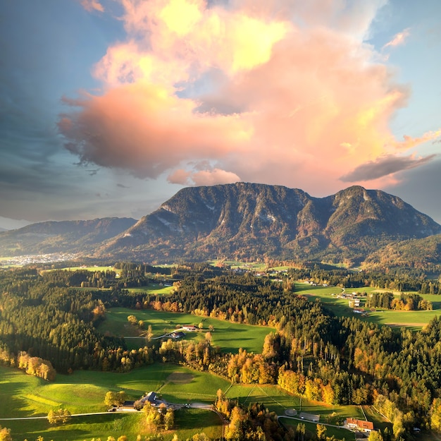Luchtfoto van groene weiden met dorpen en bos in de bergen van de oostenrijkse alpen.