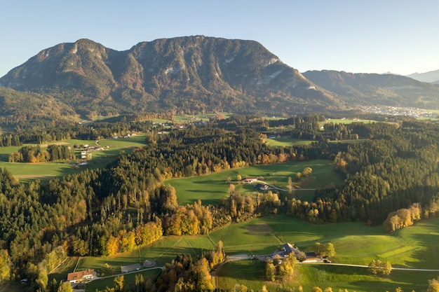 Luchtfoto van groene weiden met dorpen en bossen in de bergen van Oostenrijkse Alpen.