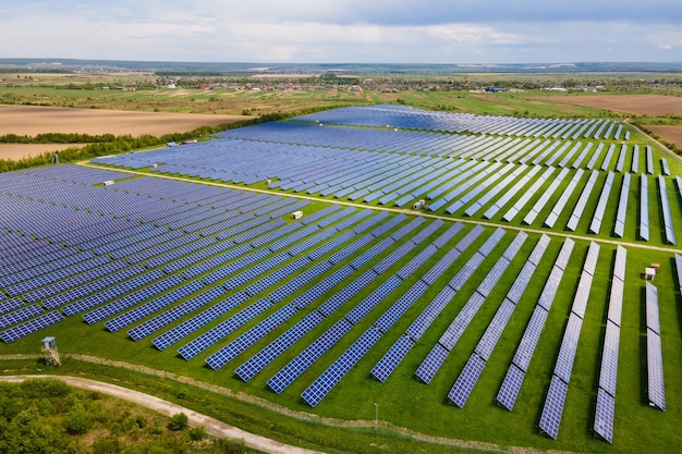 Luchtfoto van grote duurzame elektrische centrale met veel rijen fotovoltaïsche zonnepanelen voor het produceren van schone ecologische elektrische energie. Hernieuwbare elektriciteit met nul-emissieconcept.